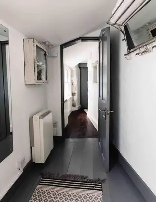 a hallway with an open door in a room at The Old Stores, Luxury beach side selfcatered holiday cottage above the beach in Porthleven