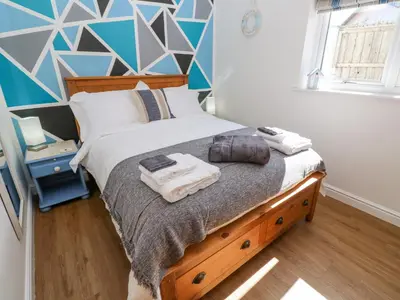 a bedroom with a bed with a blue and white wall at Kensa in Redruth