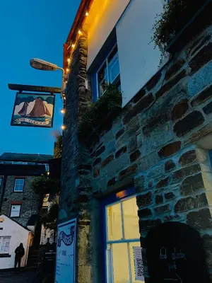 a building with a window with a sign on it at The Lugger Inn in Polruan