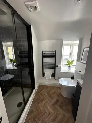 a bathroom with a shower and a toilet at The Lugger Inn in Polruan