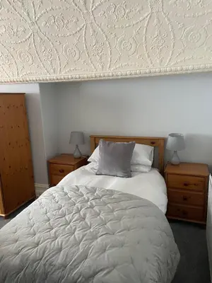 a bedroom with a large white bed with two night stands at The Lugger Fowey in Fowey