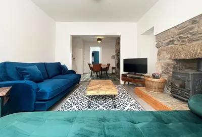 a living room with a blue couch and a fireplace at Marazion Charming Retreat for 6 with Social Garden in Marazion