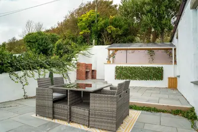 a patio with a table and chairs next to a building at Marazion Charming Retreat for 6 with Social Garden in Marazion