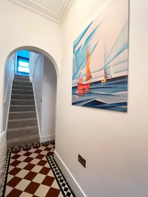a hallway with a painting on the wall and a checkered floor at Marazion Charming Retreat for 6 with Social Garden in Marazion