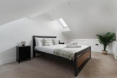 a white bedroom with a bed with white sheets and pillows at Marazion Charming Retreat for 6 with Social Garden in Marazion