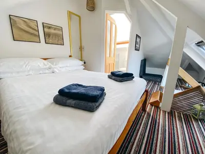 a bedroom with a bed with two blue towels on it at Beachside Guesthouse in St Ives