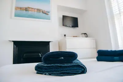 a blue towel sitting on top of a bed at Beachside Guesthouse in St Ives