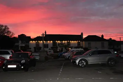 a parking lot with cars parked in front of a building at Ginentonic Cottage in Saint Keverne