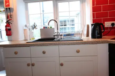 a kitchen counter with a sink and a window at Ginentonic Cottage in Saint Keverne