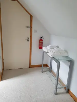 a glass table in a room with a fire extinguisher at Meadow Oak Accommodation in Bodmin