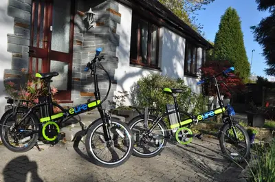 three bikes parked in front of a house at Meadow Oak Accommodation in Bodmin