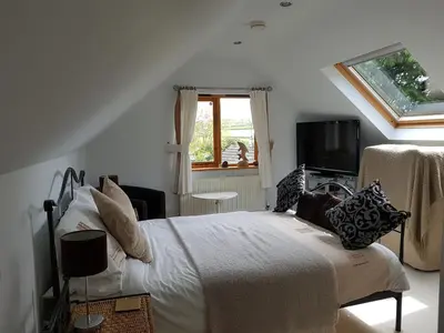 a white bedroom with a bed and a tv at Meadow Oak Accommodation in Bodmin