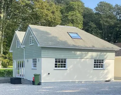 a white and green garage with a roof at Luxury retreat with hot tub & wood burner - Mylor in Falmouth