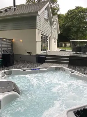 a large hot tub in front of a house at Luxury retreat with hot tub & wood burner - Mylor in Falmouth