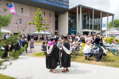a group of people in graduation robes standing outside a building at Luxury retreat with hot tub & wood burner - Mylor in Falmouth