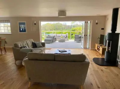 a living room with two couches and a patio at Luxury retreat with hot tub & wood burner - Mylor in Falmouth
