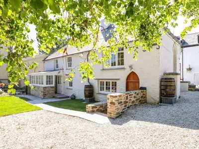 a large white house with a driveway at Trewince Manor Cottage in Truro