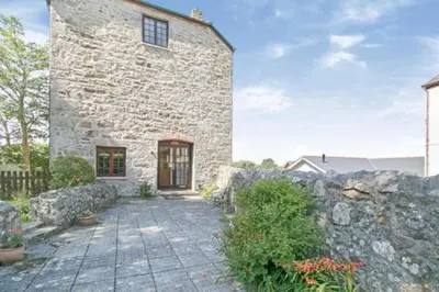 a stone house with a stone wall at The Penthouse, top floor of a Grade II Listed Mill in Praze an Beeble