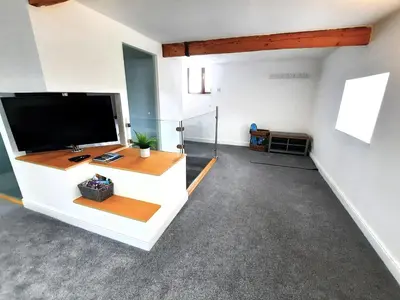 a living room with a large flat screen tv at The Penthouse, top floor of a Grade II Listed Mill in Praze an Beeble