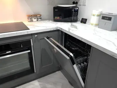 a kitchen with an open dishwasher in a counter at The Penthouse, top floor of a Grade II Listed Mill in Praze an Beeble