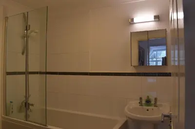 a bathroom with a glass shower and a sink at Flat 18 Pochin House in St Austell