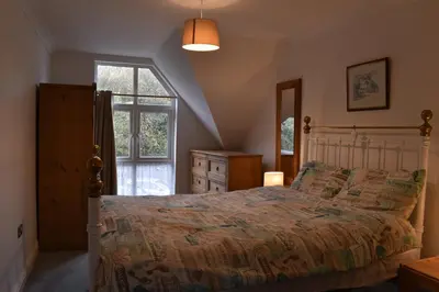 a bedroom with a large bed and a window at Flat 18 Pochin House in St Austell