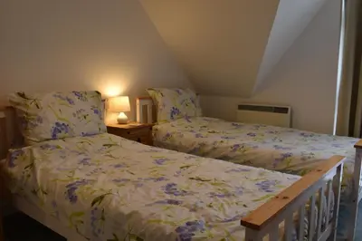 a bedroom with two beds and two lamps at Flat 18 Pochin House in St Austell