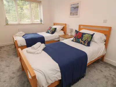 a bedroom with two beds and a window at Brewers Cottage in Looe