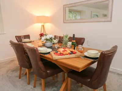 a dining room table with a bowl of fruit and a mirror at Brewers Cottage in Looe