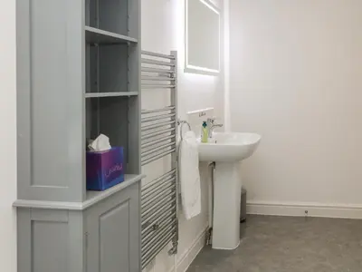 a white bathroom with a sink and a mirror at Brewers Cottage in Looe