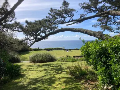 a view of a park with the ocean in the background at Brewers Cottage in Looe