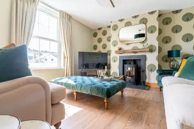 a living room with a couch and a table and a fireplace at Chyvounder in St. Agnes