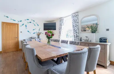 a dining room with a wooden table and chairs at Chyvounder in St. Agnes