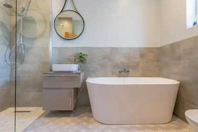 a bathroom with a tub and a sink and a mirror at Chyvounder in St. Agnes