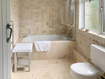 a bathroom with a tub and a toilet and a sink at Castle Cottage in Ruan Lanihorne