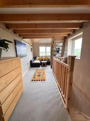 a room with a staircase and a living room at Sea View Nook in Porthtowan