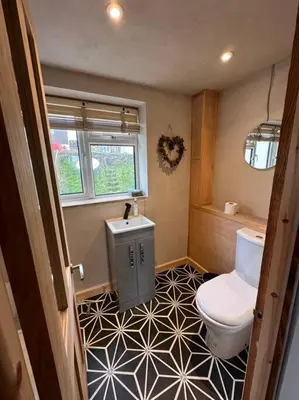a bathroom with a toilet and a black and white tile floor at Sea View Nook in Porthtowan