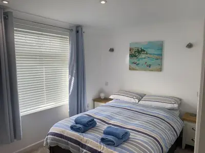 a bedroom with a bed with two towels on it at Surf's Up! Perfect base for holidays or work in Cornwall in Saint Columb Major