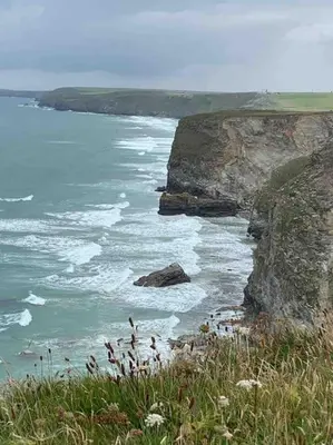 a view of the ocean from a hill with grass at Surf's Up! Perfect base for holidays or work in Cornwall in Saint Columb Major