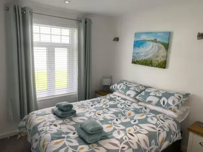 a bedroom with a bed with towels on it at Surf's Up! Perfect base for holidays or work in Cornwall in Saint Columb Major