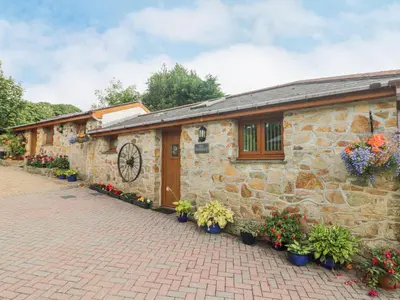 a stone building with flowers in front of it at The Hideaway in St Austell