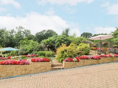 a garden with pink flowers in a park at The Hideaway in St Austell