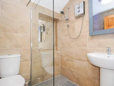 a bathroom with a shower and a toilet and a sink at The Hideaway in St Austell