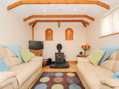 a living room with two couches and a fireplace at The Hideaway in St Austell
