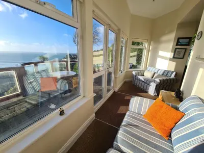 a living room with a couch and a large window at Lower Tresulian in Saint Mawes