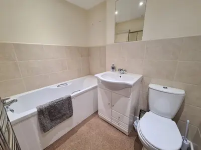 a white bathroom with a toilet and a sink at Lower Tresulian in Saint Mawes