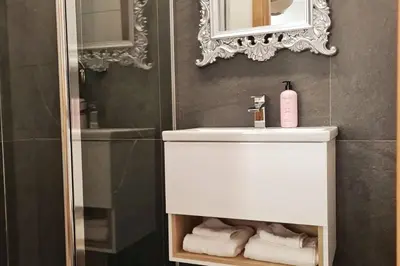 a bathroom with a white sink and a mirror at 4 Bed Villa Sleeps 8 -Private Terrace-Free parking in St Austell