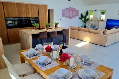 a living room with a table with plates and glasses at 4 Bed Villa Sleeps 8 -Private Terrace-Free parking in St Austell