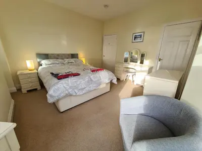 a bedroom with a bed and a chair in it at Upper Tresulian in Saint Mawes