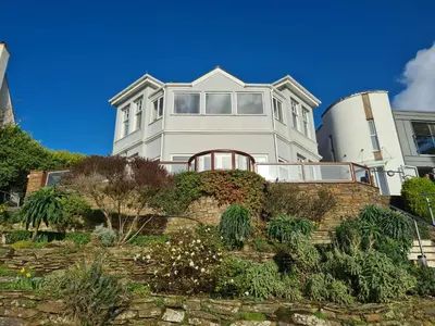 a large white house on top of a brick wall at Upper Tresulian in Saint Mawes